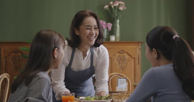 Adult SME owner work at busy small cafe bar pub on cozy day carry plate tray for group asia people friend party at vegan shop. Enjoy talk order fresh menu eat meal drink fine dish diet salad bowl.
