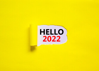 2022 hello new year symbol. Concept words Hello 2022 appearing behind torn yellow paper. Beautiful yellow background. Business, hello 2022 new year concept, copy space.