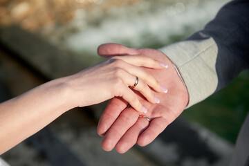 Newlywed couple's hands with wedding rings, copy space. Wedding couple, bride and groom, hands with rings, closeup