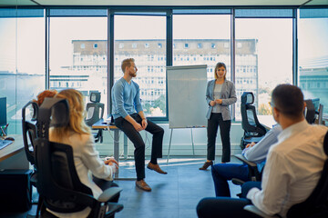 Businesswoman leading a presentation at flip chart in office