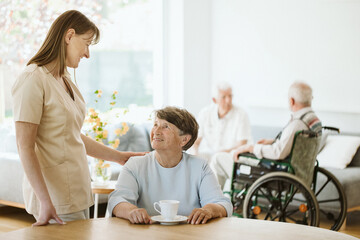 Happy senior woman and helpful caregiver, nursing home concept photos