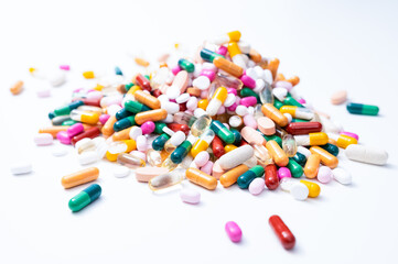 Pile of drugs with a variety of colorful tablets, pills, capsules and dragees on white background. Health service, care, pharmacy, medical or pharmaceutical concept. 