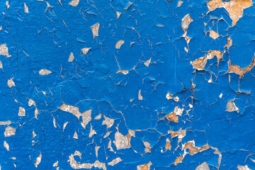 Wall background with cracked and worn blue paint.
