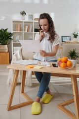 Young businesswoman reading and analyzing data in printed report