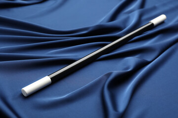 Naklejka premium Beautiful black magic wand on blue fabric