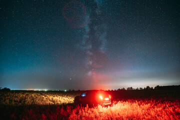 Night Starry Sky With Glowing Stars Above Countryside Road Landscape With SUV Car Vehicle...