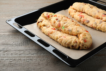 Baking tray with raw homemade Stollens on wooden table, closeup. Traditional German Christmas bread
