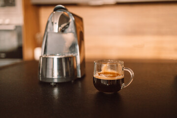 Cozy home desk table with modern coffee machine, glass of cup. Breakfast