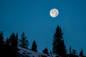 beautiful fullmoon at a autumn morning on the mountains in the sunrise