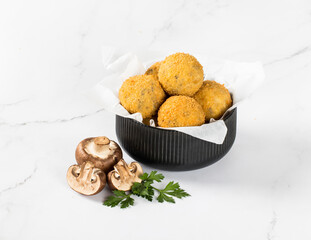 Deep-fried chicken cheese balls, croquettes with champignons in a serving bowl on a white background