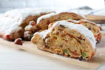 Traditional Christmas Stollen with icing sugar on white wooden table