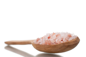 Himalayan salt with a wooden spoon, close-up, isolated on white.