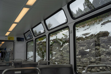 Looking out a train window at the snowy landscape of the Swiss Alps near Lauterbrunnen,...