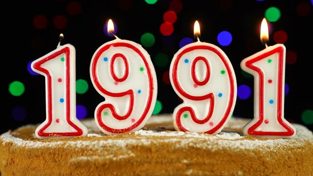 Birthday cake with white burning candles in the form of number 1991