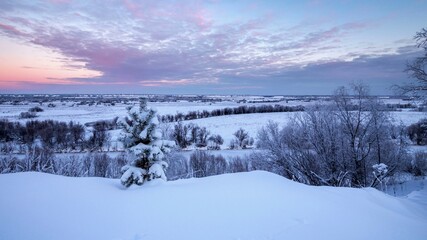 Sunrise over the snow-covered hillside. Winter landscapes