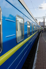 Odessa, Ukraine - 10|18|2020: A passenger train, a compartment carriage outside of a blue-and-blue color, stands on a pirone.