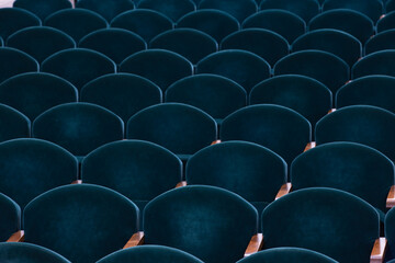 rows of soft velvet armchairs in the theater auditorium