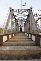 Railroad and railway bridge and a man stands on the train tracks in the middle