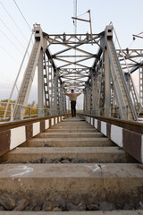 Railroad and railway bridge and a man stands on the train tracks in the middle