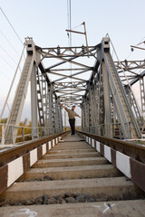 Railroad and railway bridge and a man stands on the train tracks in the middle