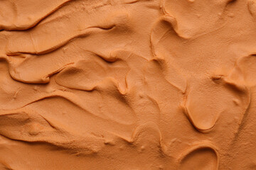 Brown play dough as background, top view