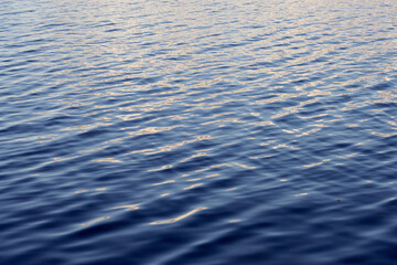 Light ripples of waves on the surface of the lake water.