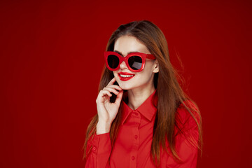 attractive woman in red shirt sunglasses fashion red background