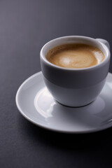 Cup of coffee on dark paper background. Close up. 
