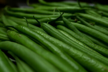 Close-up of fresh green beans lined up. Immature pods of common beans. Vegetable for vegetarian.