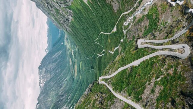 Trollstigen, Andalsnes, Norway. vertical, vertical shot, vertical video Cars Goes On Serpentine Mountain Road Trollstigen. Famous Norwegian Landmark And Popular Destination. Norwegian County Road 63