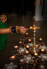 Fototapeta na wymiar Woman lighting lamp for Diwali 