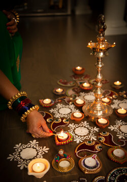 Woman lighting Diwali lamp 