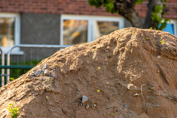 A pile of sandy dirt outside a building.