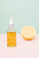 Dropper bottle of  face oil with lemon at the background, winter skin care
