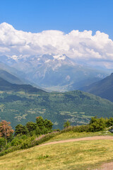 Summer mountain landscape near Mestia, Svaneti region, Georgia, Asia. Snowcapped mountains in the background. Blue sky with clouds above. Christian cross on the top of the hill. Travel destination