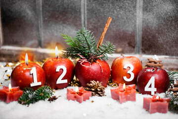 Beautiful card with advent candles and christmas apples in front of old window in snow. 2nd advent, 2 candles burning. Christmas Eve.