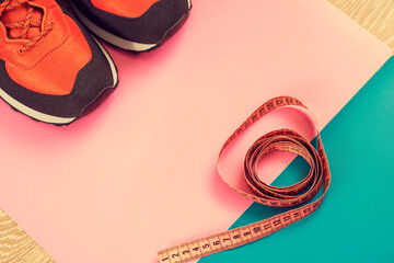  sneakers on a colored  surface.   sport shoes on colorful background.  Fitness accessories. Measuring tape, centimeter.