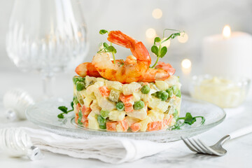 Olivier salad with shrimps  on a plate. Traditional Russian festive salad. Selective focus
