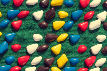 texture with multi-colored stones. objects of different colors on a green background. multicolored...