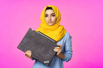 cheerful muslim woman in yellow hijab learning laptop technology