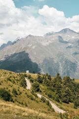 Summer mountain landscape near Mestia, Svaneti region, Georgia, Asia. Snowcapped mountains in the background. Blue sky with clouds above. Georgian travel destination