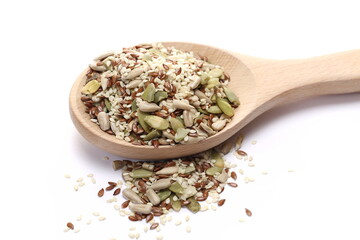 Seed mix, sunflower, sesame, linseed and pumpkin seeds in wooden spoon isolated on white 