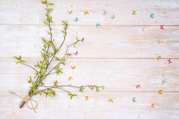 bouquet of green twigs of pussy willow and decorative butterflies on a wooden background. There is room for text.
