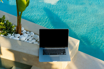 a laptop on the deckchair in swimming pool