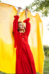 festively outdoors yellow cloth on the background of posing red dress