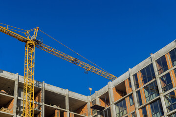 Large construction site with busy tower cranes at high-rise building