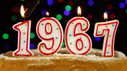 Birthday cake with white burning candles in the form of number 1967