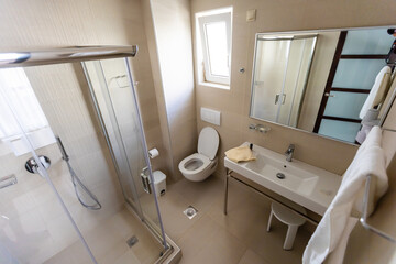 Obraz na płótnie Canvas Spacious bathroom in gray tones with heated floors, walk-in shower, double sink vanity.