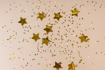 Golden confetti and stars. Top view. Holidays background. Happy New Year and Christmas 2022 celebration