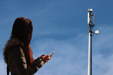 Girl uses cell phone with a communication antenna